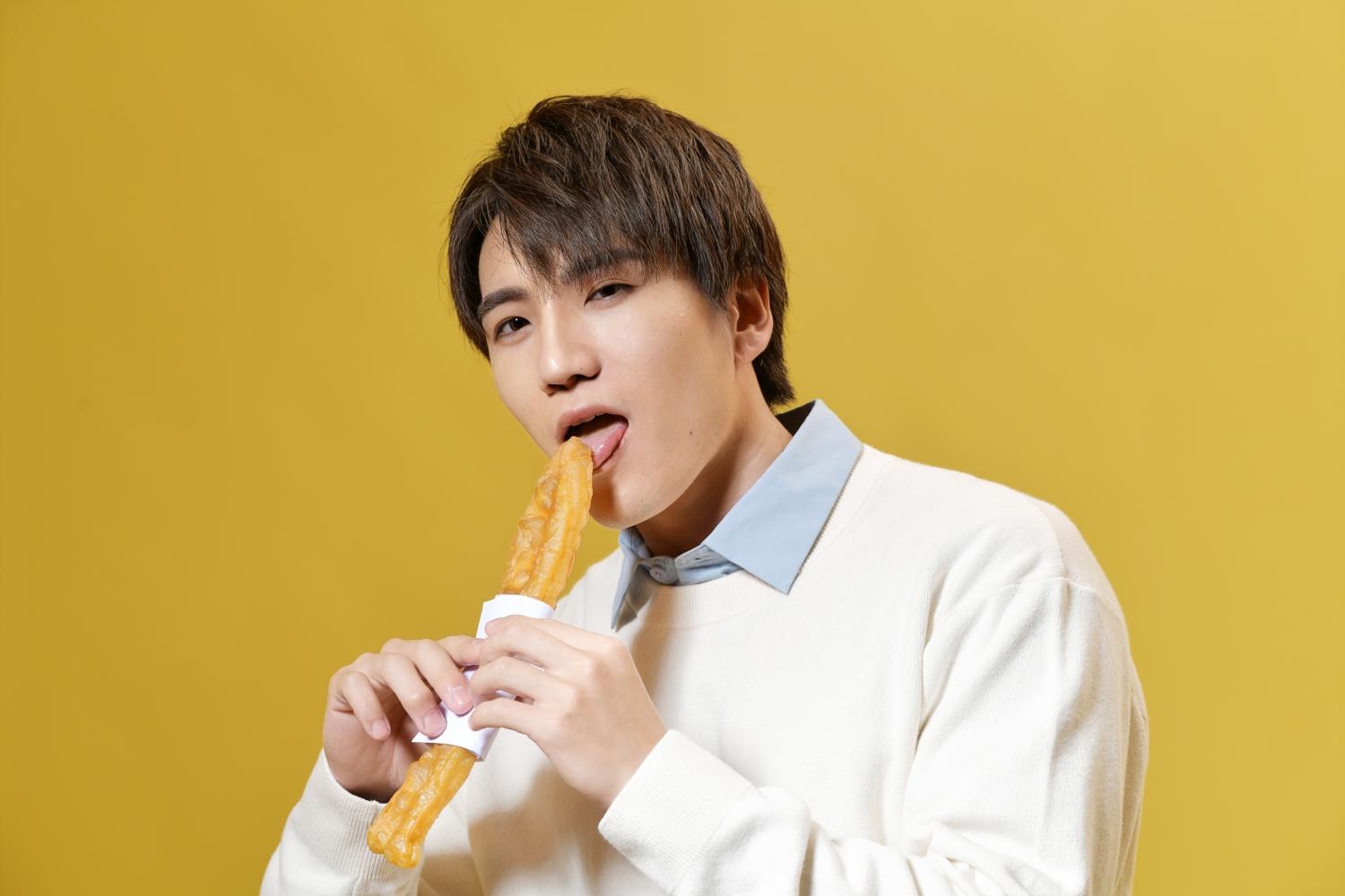 成宮仁挑戰拿油條拍美照。(圖/陳郁翔提供)