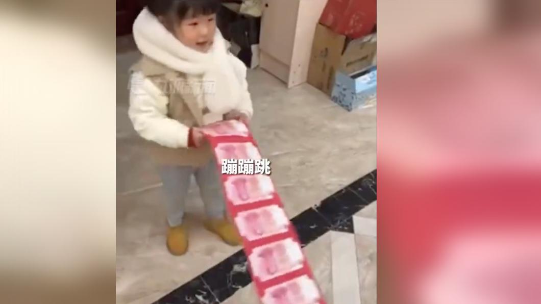 女童邊拿紅包邊給爺爺拜年。(圖/翻攝自《九派新聞》微博)
