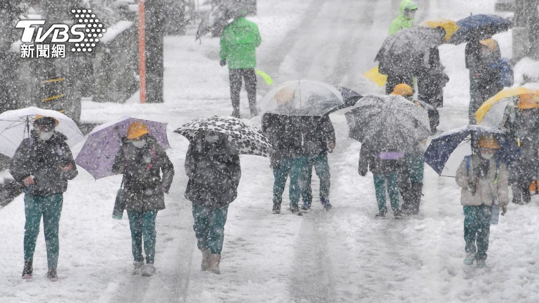 日本北陸的富山縣被一片白茫茫大雪籠罩,民眾只能冒著雪出門。(圖/達志影像美聯社)
