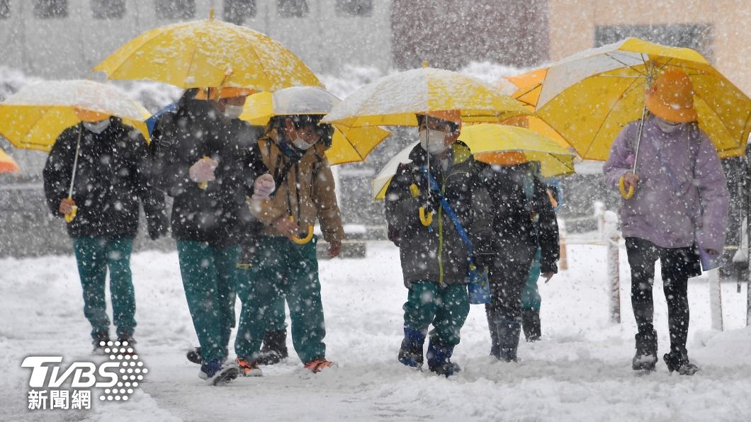 日本學童在大雪中撐傘上學。(圖/達志影像美聯社)