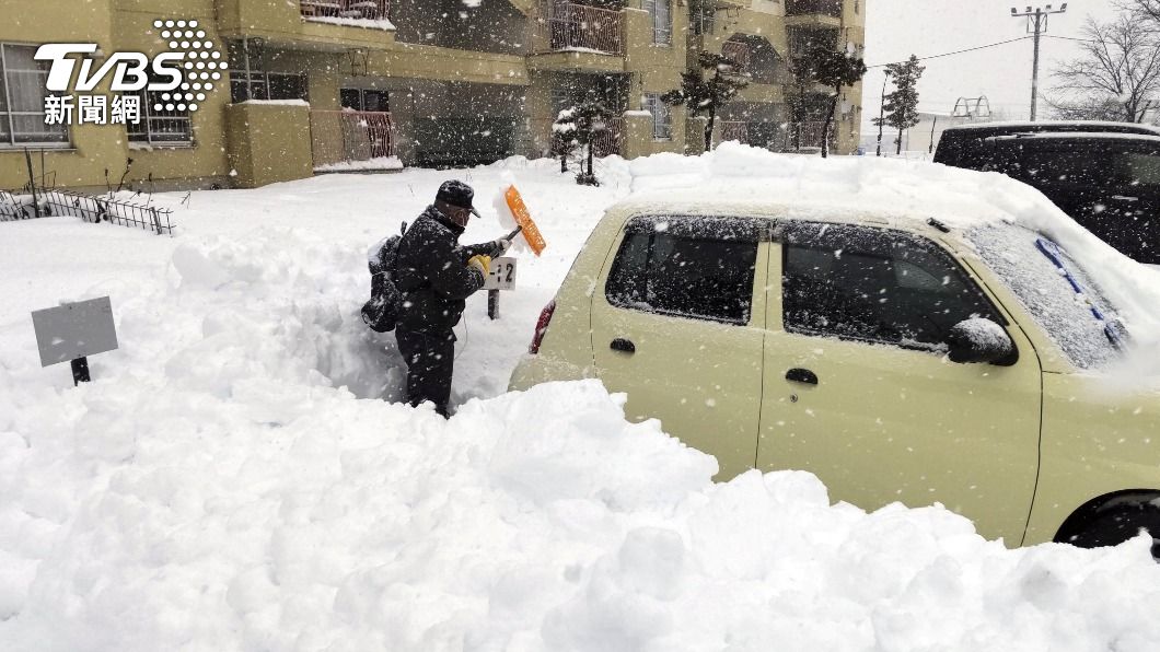 北海道居民只能在漫天大雪中拚命剷雪,否則連自家車輛都要被雪埋住。(圖/達志影像路透社)