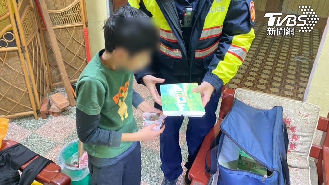男童握著警方提供的暖暖包,準備吃便當。(圖/警方提供)
