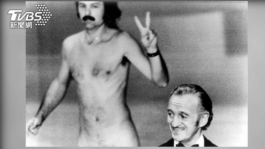 男星大衛尼文(David Niven)在頒獎時,攝影師歐培爾(Robert Opel)竟然裸體比和平手勢闖進畫面。(圖/達志影像美聯社)