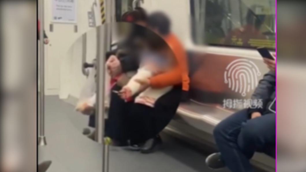 婦女在車廂內幫孩童點菸。(圖/翻攝自拇指視頻 微博)