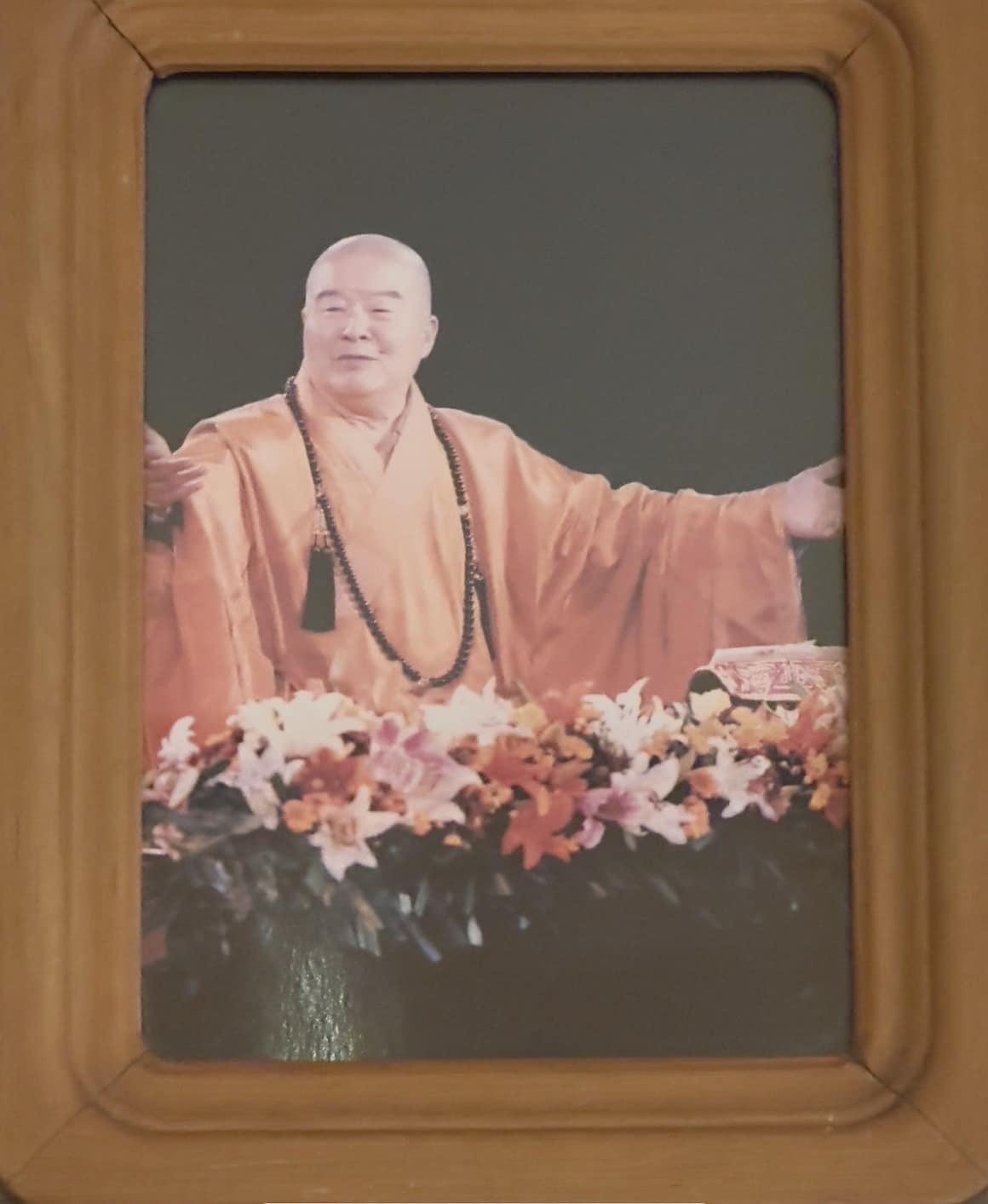 星雲大師滿臉慈愛,展開雙臂。(圖/翻攝自LIULI 琉璃工房臉書)