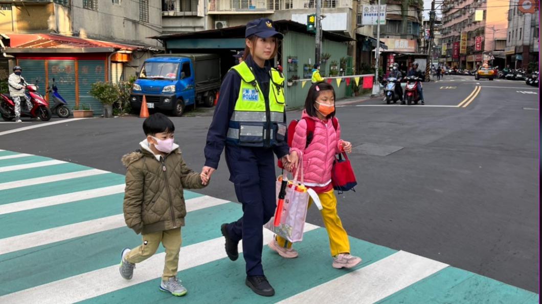 中和分局女警貼心地牽著學童們過馬路。(圖/TVBS)
