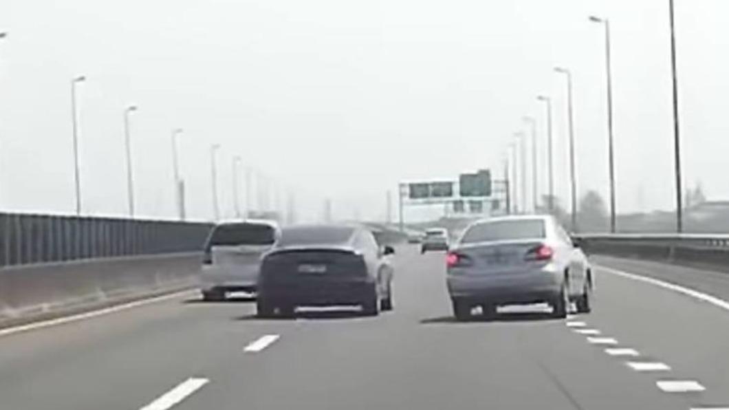 黑色特斯拉不顧外側有慢慢加速的車，瞬間打方向燈就立刻變換車道。（圖／翻攝自爆料公社臉書）
