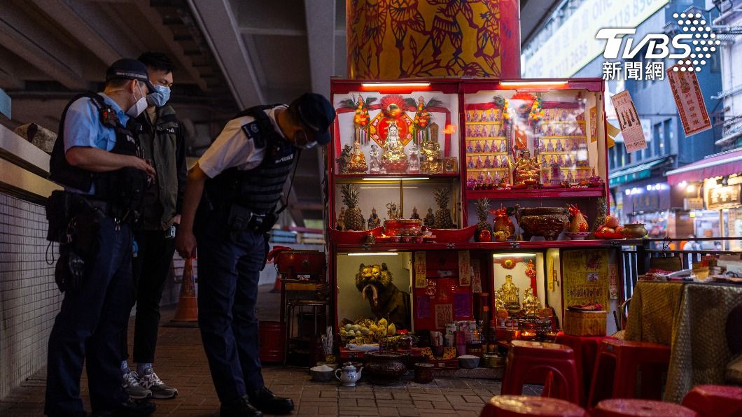 警察巡邏時,也忍不住駐足觀察橋下擺滿的神像和供品。(圖/達志影像美聯社)