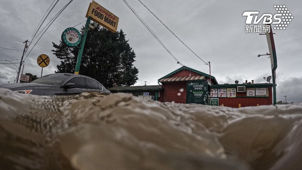 雖然大雨已經停歇,但部分地區仍積水未退,車輛通過時激起不小的水花。(圖/達志影像路透社)