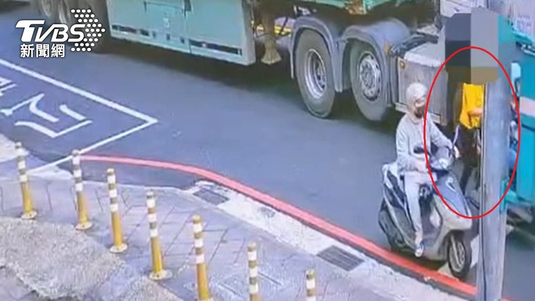 婦人走在曳引車旁邊,下一秒就遭撞倒捲進車底。(圖/TVBS)