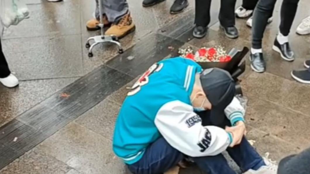 男子不顧旁人勸告,下雨天仍繼續等待。(圖/翻攝自微博)