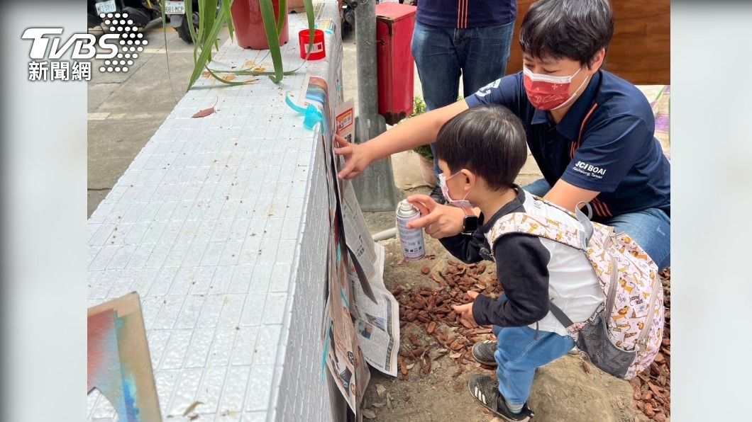 拿噴漆在報紙上盡情圖畫,大人帶著小孩創作。(圖/記者翻攝)