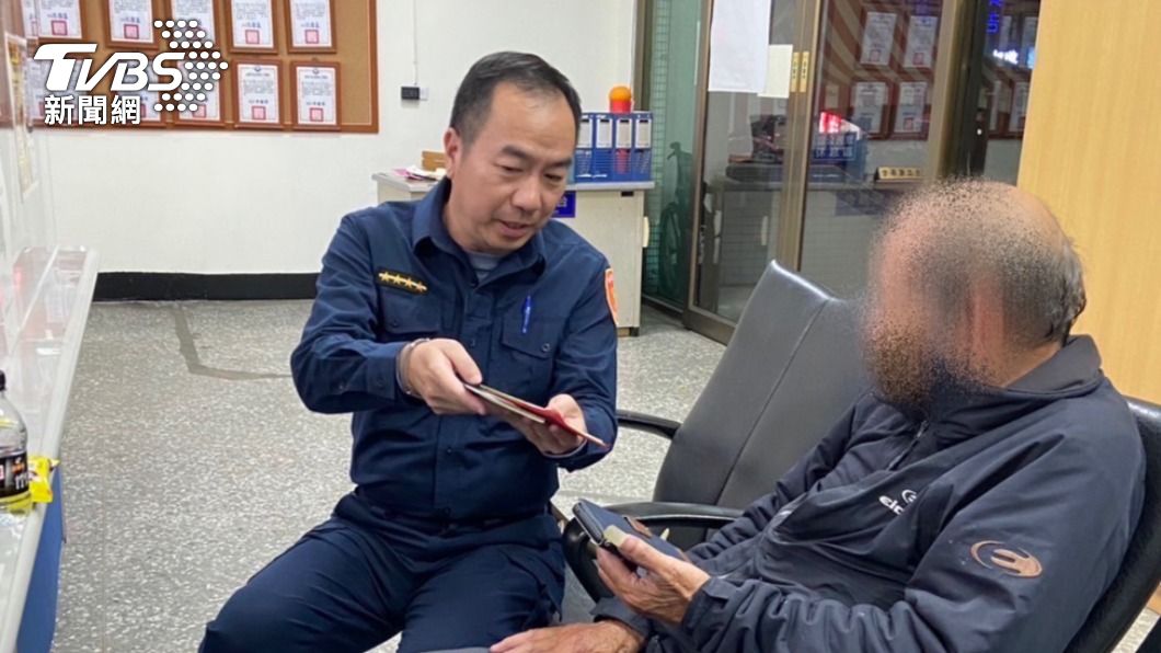 老翁手拿多本存摺和現金徘迴路上,警方上前關心。(圖/警方提供)