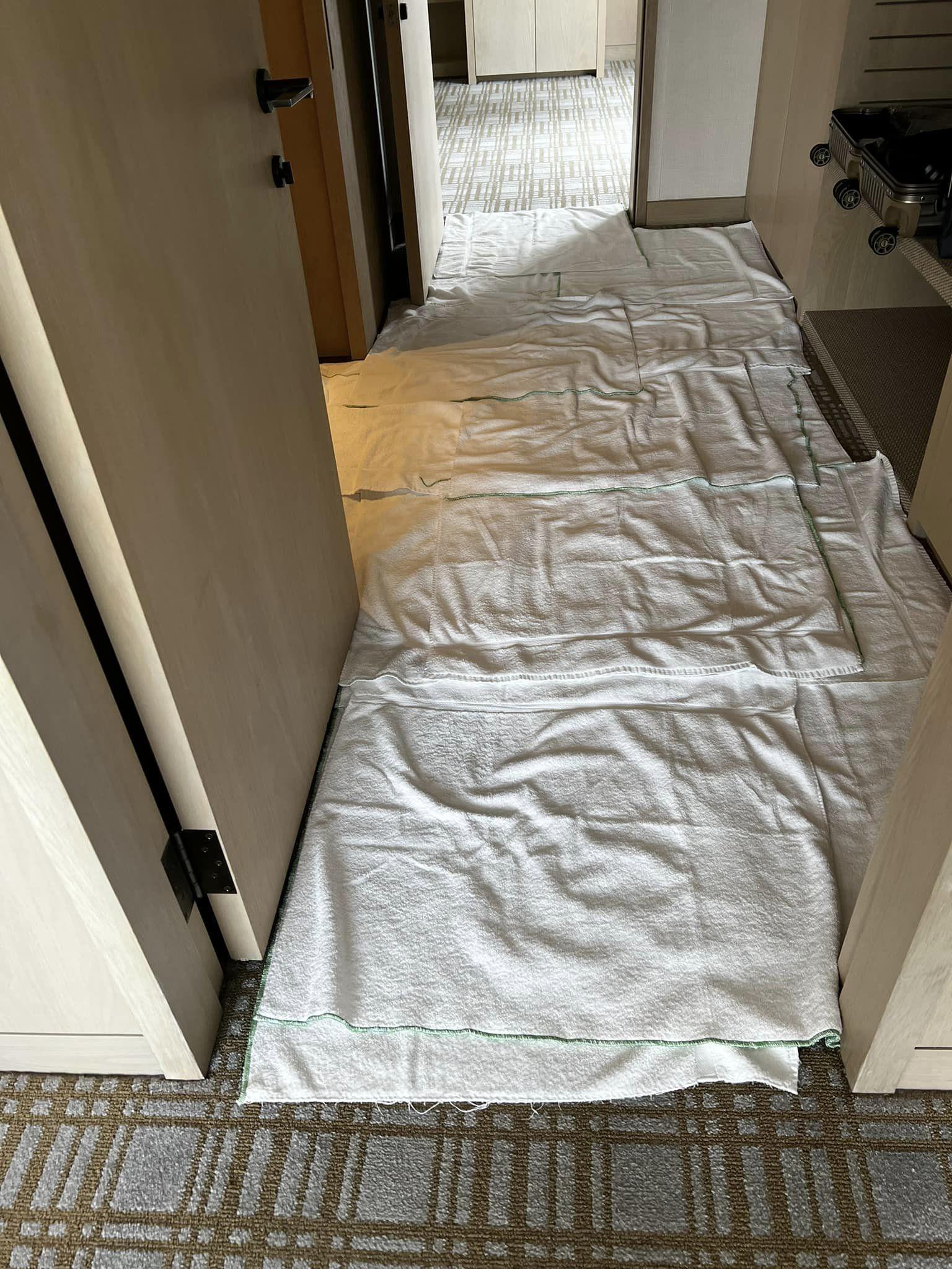 周小姐入住台北一間五星酒店,控地板浸濕狀況嚴重,房務僅拿毛巾鋪地板。(圖/翻攝Facebook Sarah Chou)