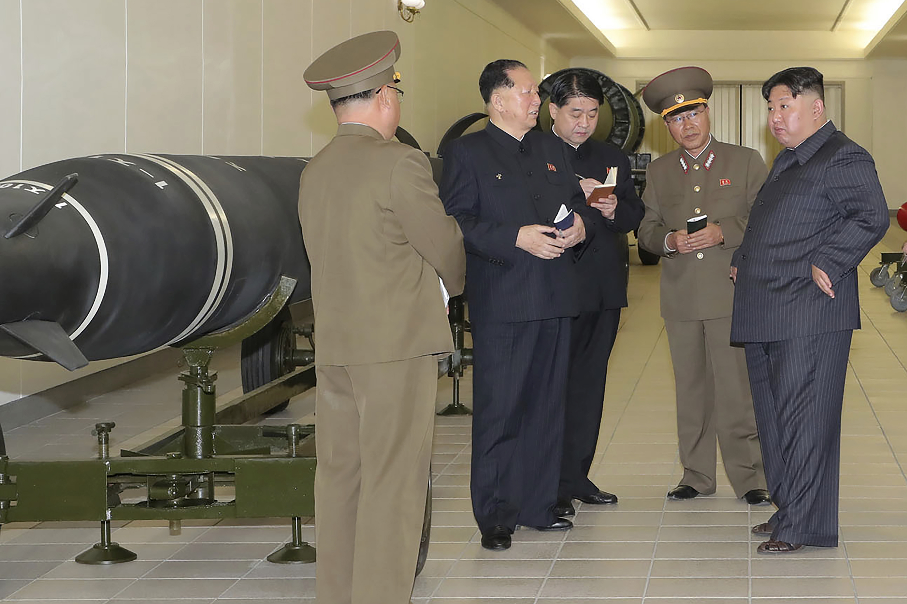 北韓領導人金正恩在視察飛彈部隊基地時,聽取高階軍官所做的簡報(畫面來源:AP)