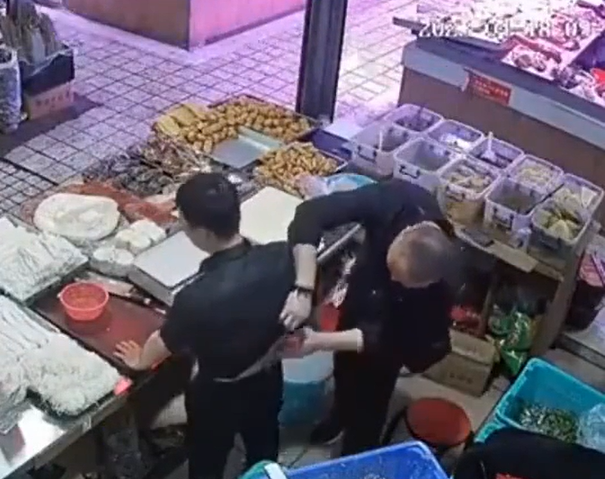陌生男子把膏藥貼在攤主的腰部。(圖/翻攝自微博)