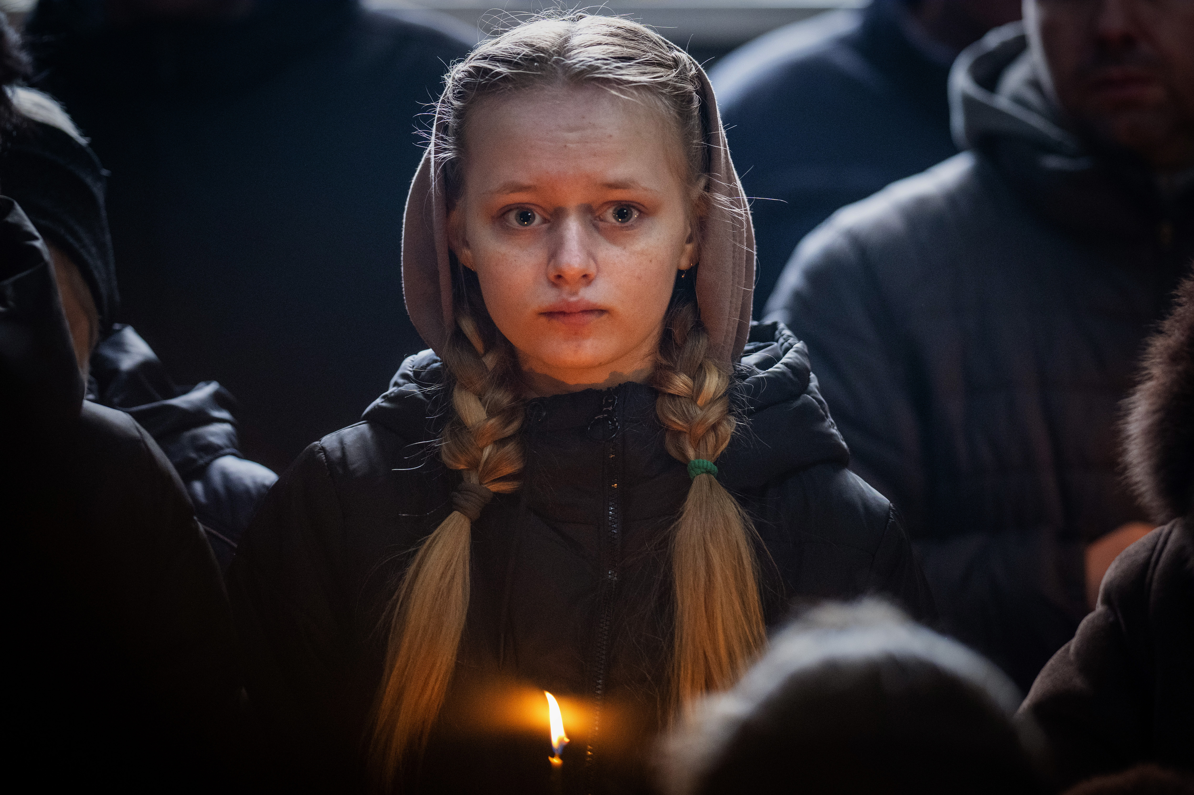 烏克蘭女孩手持火燭為保衛巴赫姆特的前線將士祈福,期盼戰事早日落幕。(畫面來源:AP)