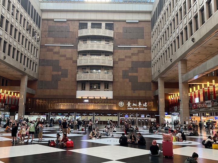 台北車站大廳常見移工與旅客席地而坐。(圖/翻攝自小笠原欣幸臉書)