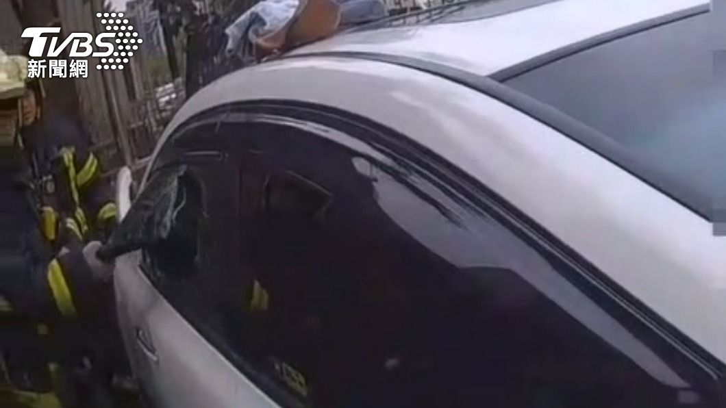 消防人員敲擊距離男童較遠的車窗。（圖／TVBS）