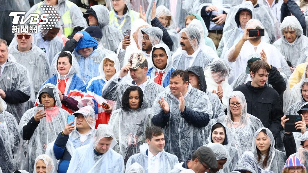 英國民眾在雨中熱情高唱國歌。(圖/達志影像美聯社)
