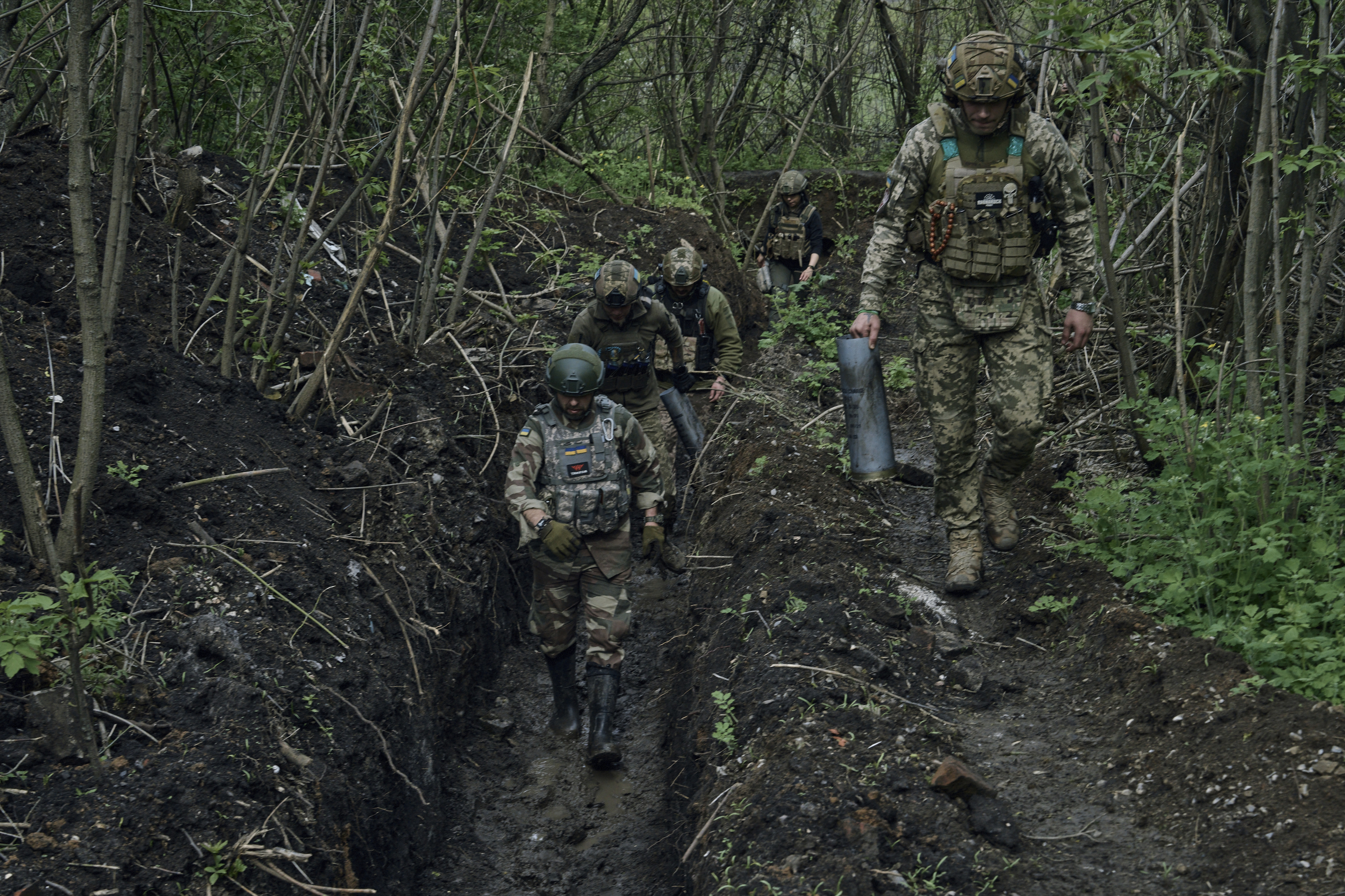 烏克蘭適逢融雪期，士兵走在泥濘的戰壕中，全力防守俄軍的攻擊。(畫面來源：AP)