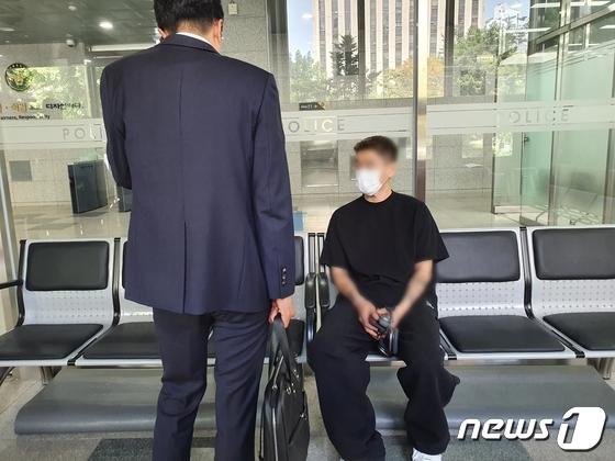 崔男今天步入警局時手上還拿著耳機跟電子煙,令韓媒咋舌他大搖大擺的態度。(圖/翻攝自News1)