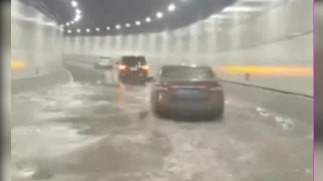 已經在該處的車輛駕駛只能放慢速度行駛,通過淹水路段。(圖/翻攝自微博)
