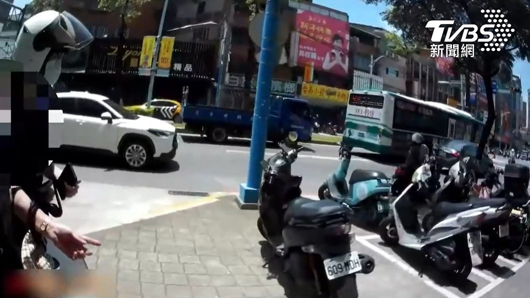 警員攙扶老婦人至陰涼處休息。(圖/TVBS)