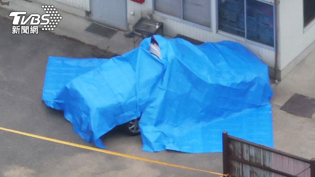 中彈警車被蓋上藍布。(圖/達志影像美聯社)