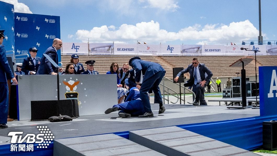 拜登摔倒時,隨扈趕緊衝上台。(圖/達志影像美聯社)