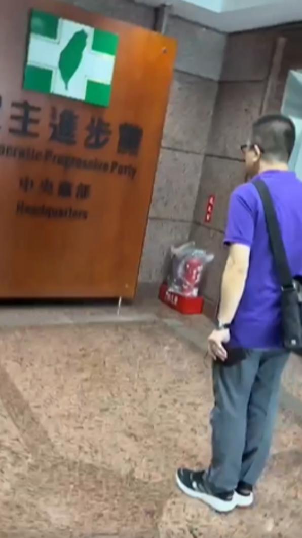 林男固向民進黨中央招牌鞠躬道別。(圖/翻攝自張益贍臉書)