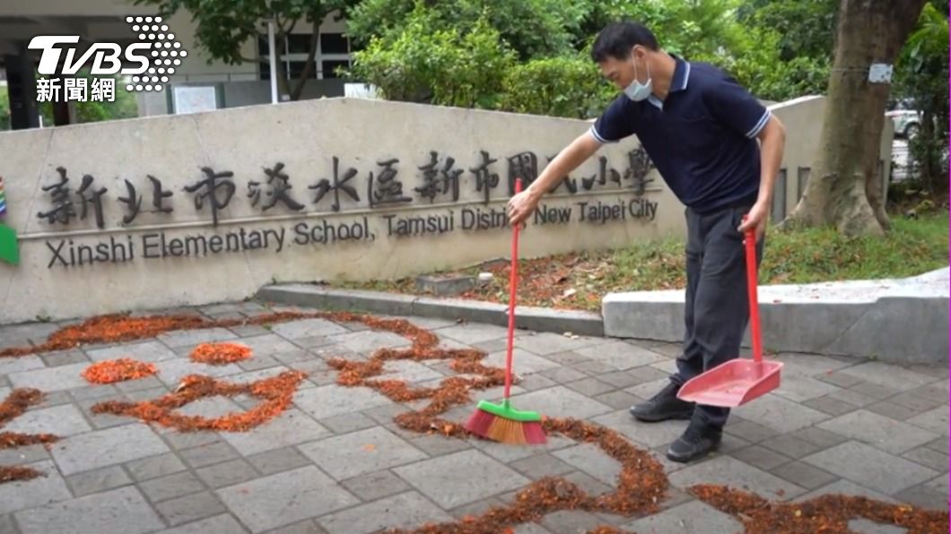 國小警衛用鳳凰花排列成卡通圖案。(圖/校方提供)