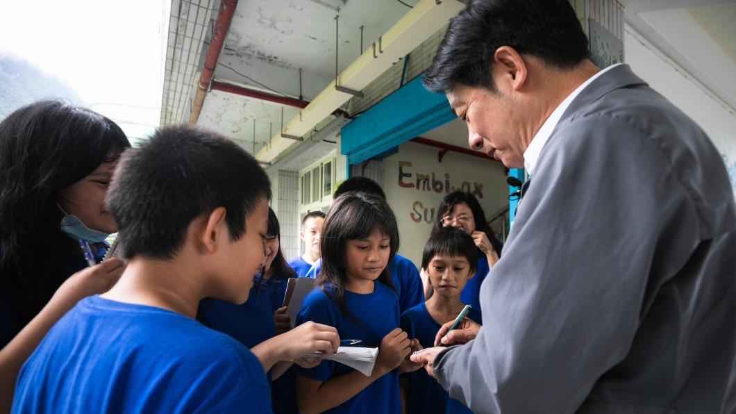 賴清德替學童簽名。(圖/總統府提供)