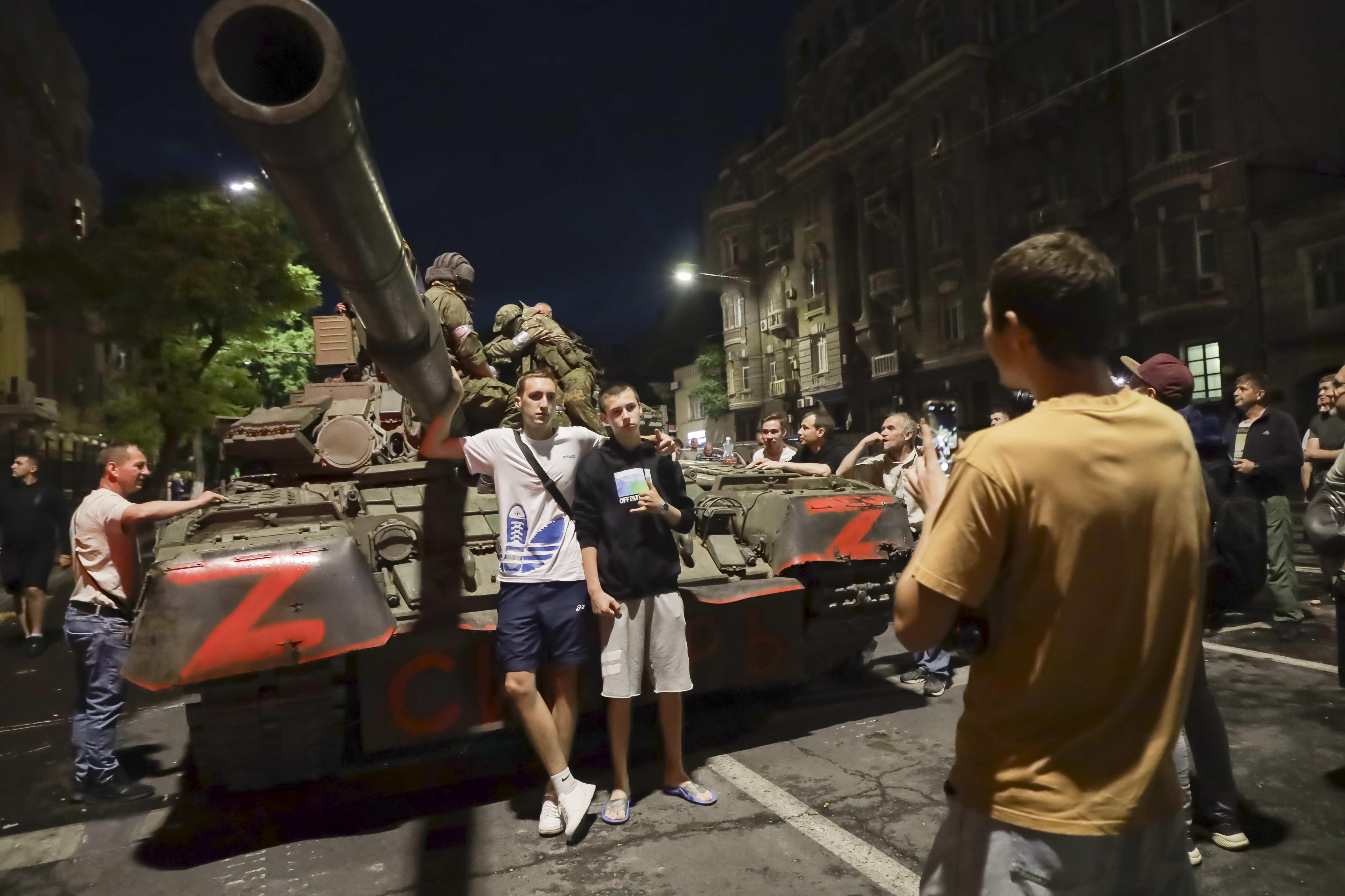 年輕人在瓦格納傭兵集團的坦克前合照。(照片來源:AP)