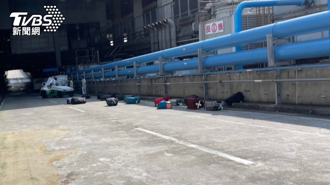行李櫃互相碰撞後,旅客的行李噴出散落在機坪地上。(圖/讀者提供)