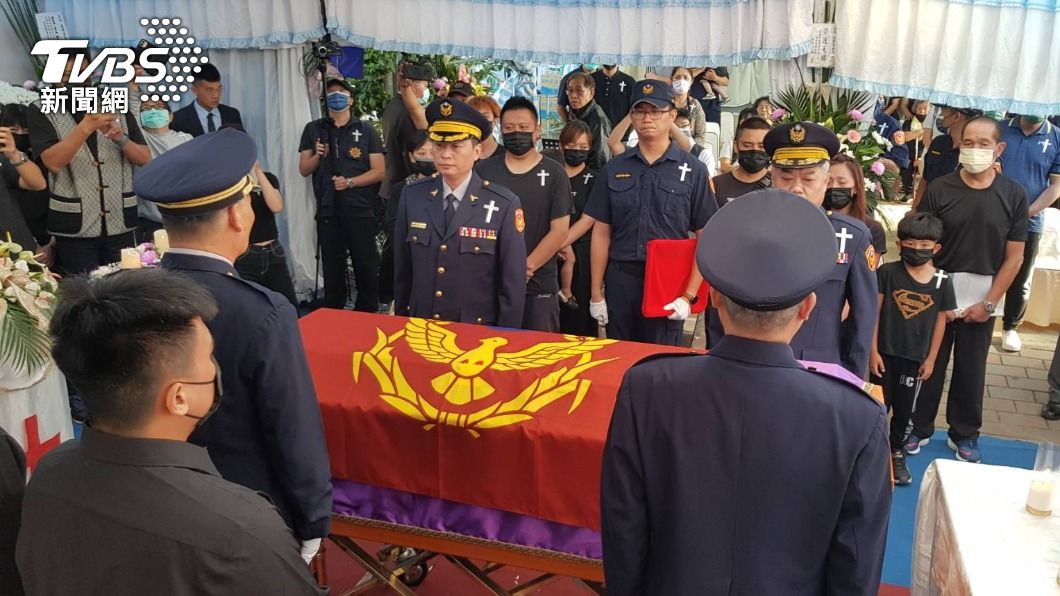 同僚在高姓員警棺木覆蓋警旗。(圖/警方提供)