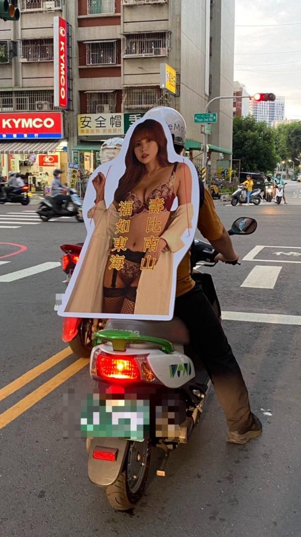 一名網友當眾把三上悠亞的人形立牌背在肩上。(圖/翻攝自「路上觀察學院」臉書)