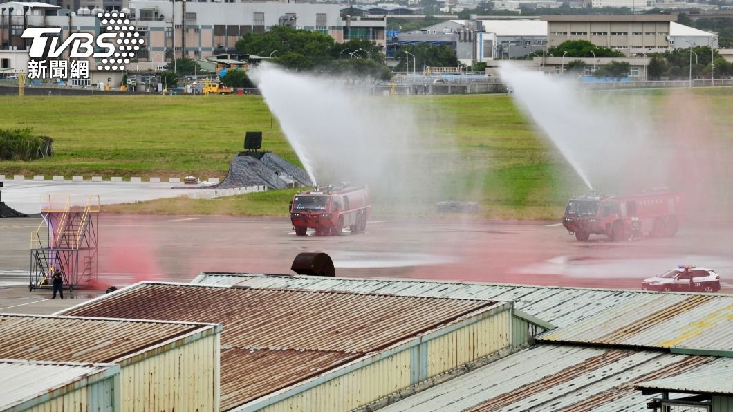 機場消防隊駛入機坪噴灑水柱撲滅火勢，將傷患送上救護車後送。（圖／胡瑞麒攝）