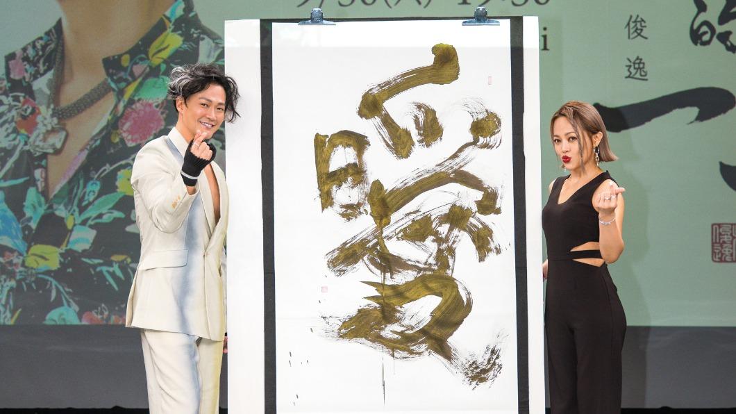 林俊逸(左)收到戴愛玲送的大毛筆,當場揮毫「曖」字送給她。(圖/媒體棧提供)