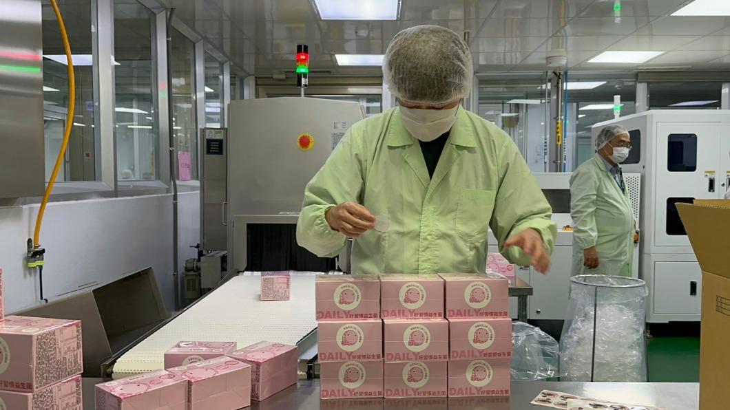李岳親自到工廠視察,替包裝好的益生菌親手貼上品牌貼紙。(圖/李岳提供)