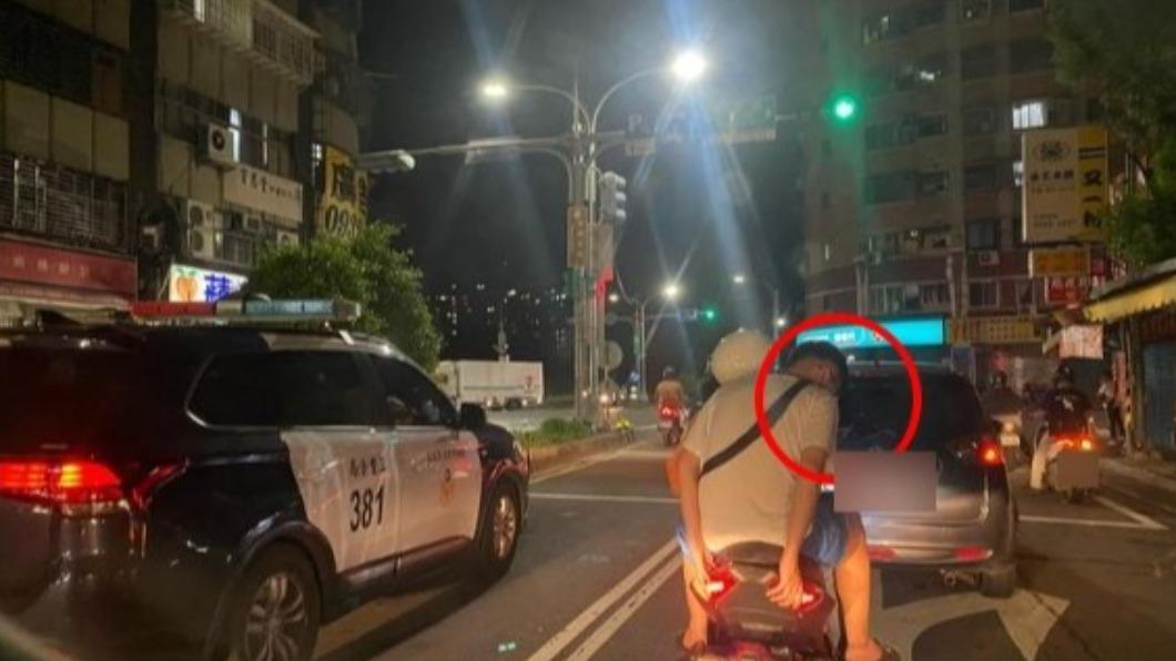 前方該名男子因未戴安全帽且看到左方有警車,嚇得趕緊扭頭躲在前方騎士右側。(圖/翻攝自路上觀察學院)