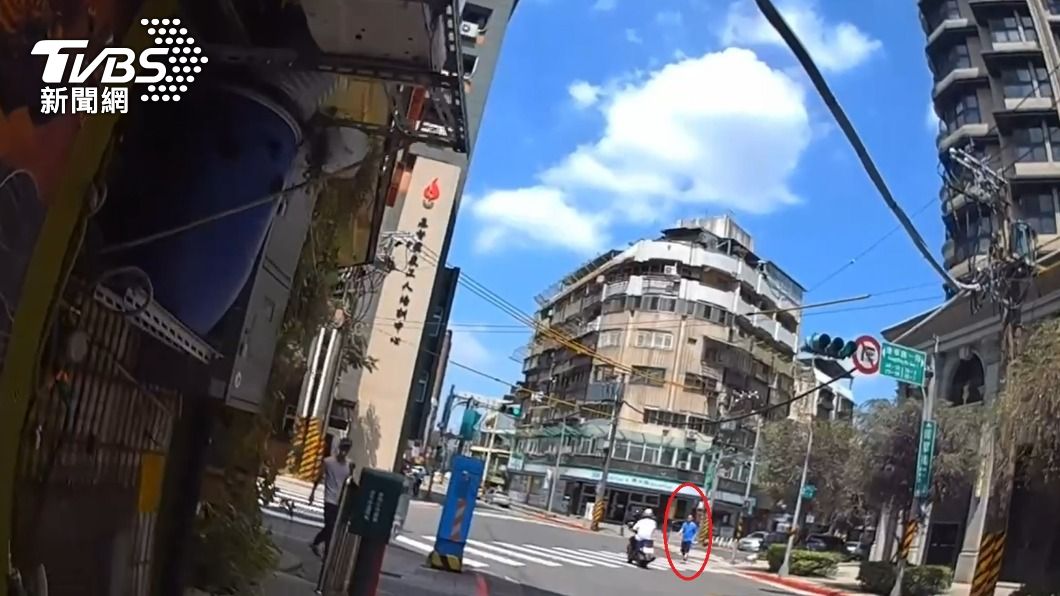 身穿藍衣的陳姓通緝犯闖紅燈而被攔查，身分因此曝光。（圖／TVBS）