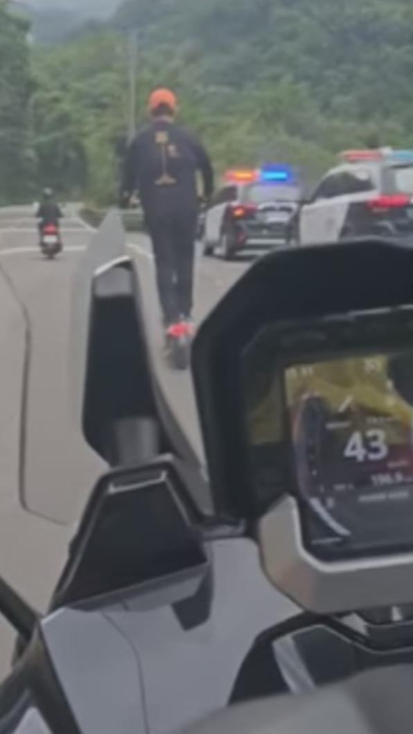 警車在旁男子也絲毫不畏懼,持續直行。(圖/翻攝自重機車友各區路況天氣、資訊分享中心 臉書)