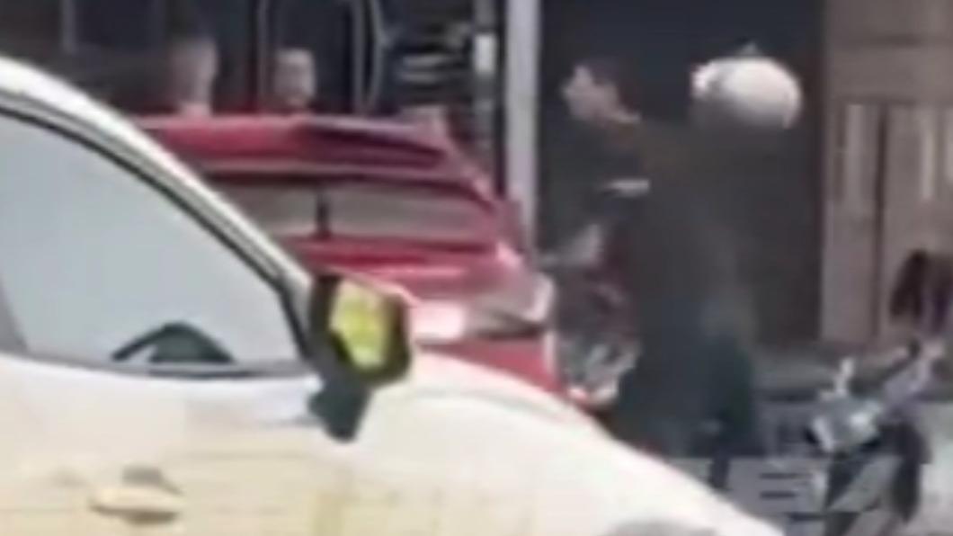 身穿黑衣的陳男拿著安全帽猛砸紅色轎車。（圖／翻攝自社會事新聞影音）