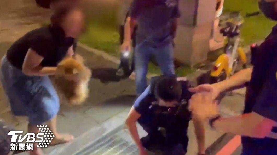 眾人齊力小狗狗順利脫身,婦人抱起小狗含淚感謝熱心員警。圖/板橋分局提供