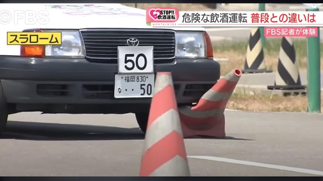 喝酒後開車上路的日本記者，隨即就撞倒路邊交通錐。（圖／翻攝自FBS福岡放送ニュース新聞影片）