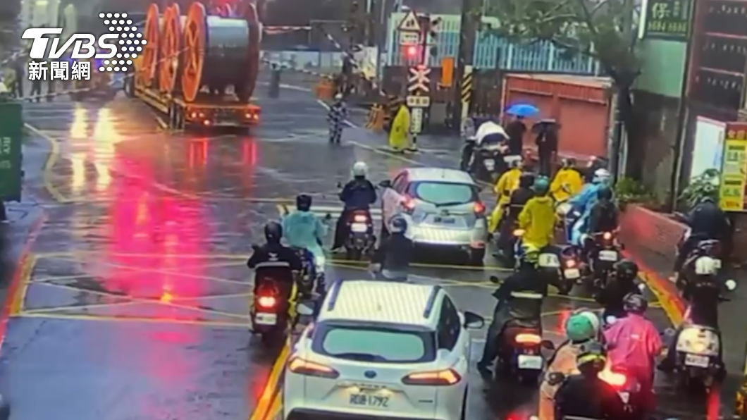 拖板車尚未脫困，平交道柵欄放下情況一度危急。（圖／TVBS）