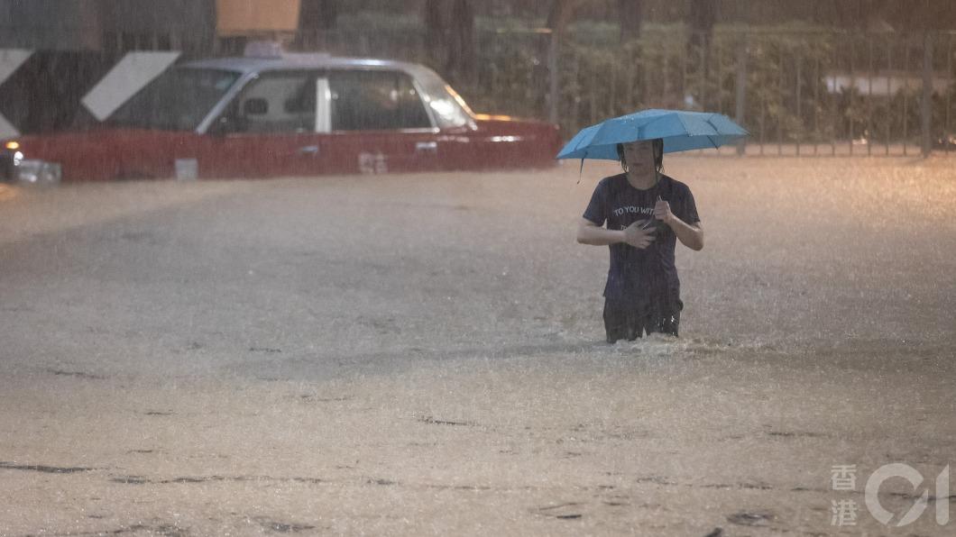 天文台發出黑色暴雨警告信號,重災區柴灣一直未停過,馬路黃泥水浸至大腿以上,有市民涉水而行。(圖/香港01)