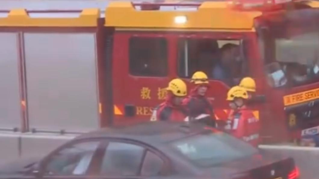 當時水幾乎快淹過車子,消防員急忙前去救援女子。(圖/翻攝自@有線新聞)