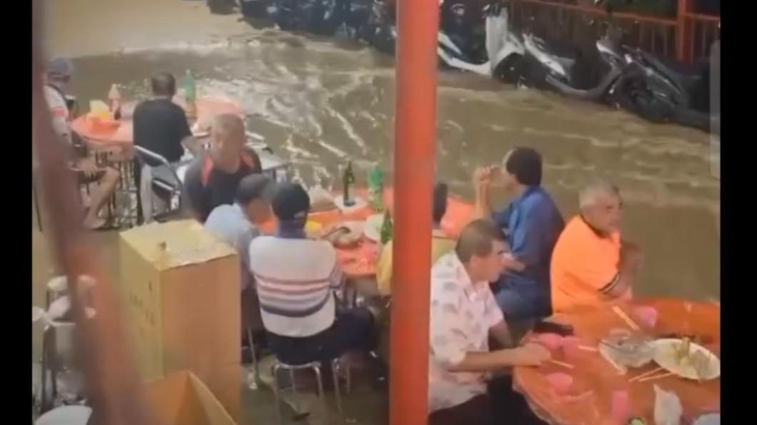 信徒在暴雨中吃流水席。(圖/民眾提供)